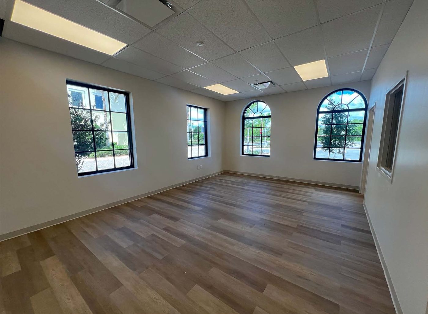 A classroom at Wellington Collegiate Academy with arched windows and wood flooring
