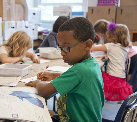 A young student concentrating on his work at his desk